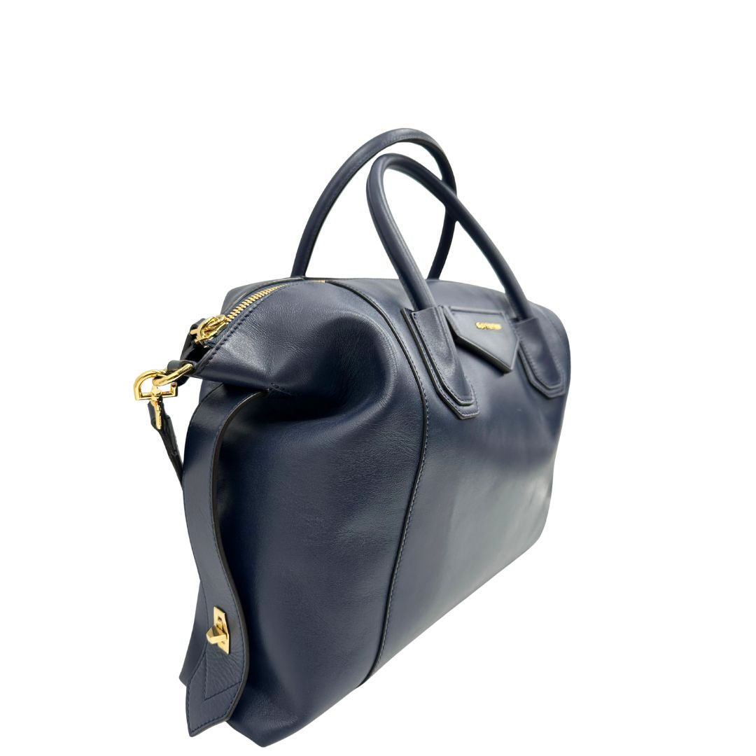 Lato destro di una Borsa Givenchy Antigona in pelle blu notte munita di doppi manici stondati, Parti metalliche dorate e una tracolla amovibile. Completa di dustbag. Originale, usata, di lusso, in ottime condizioni.