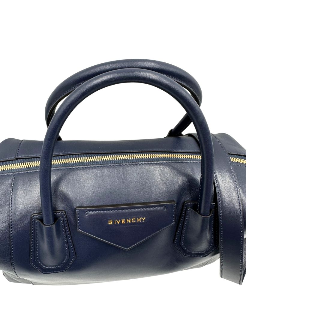 Manici di una Borsa Givenchy Antigona in pelle blu notte munita di doppi manici stondati, Parti metalliche dorate e una tracolla amovibile. Completa di dustbag. Originale, usata, di lusso, in ottime condizioni.