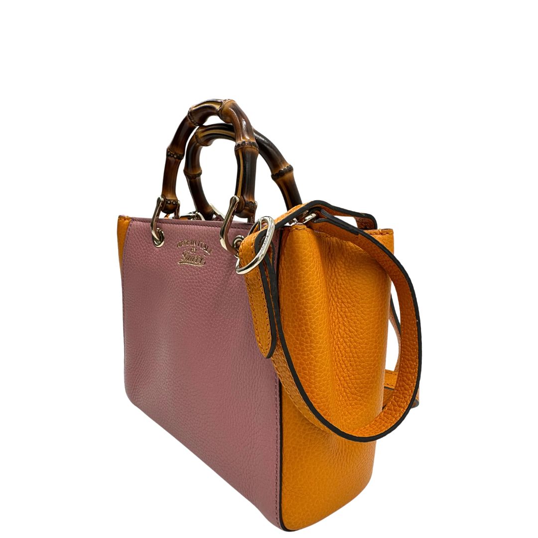 Lato sinistro, Borsa Gucci in pelle martellata bicolor con lati a contrasto arancioni e corpo principale rosa e hardware dorato.