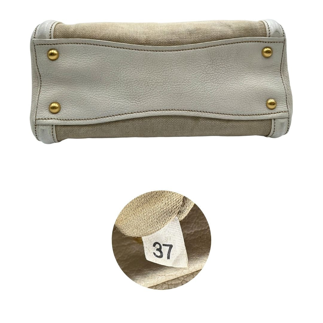 Base e codice di una borsa Miu Miu in misto lino avorio con finiture in pelle color bianco latte e parti metalliche dorate; munita di doppi manici stondati ed una tracolla amovibile e regolabile. Completa di card d'autenticità. Indossabile a mano e a tracolla.