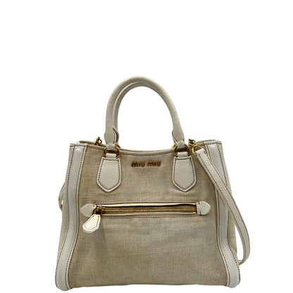 Front di una borsa Miu Miu in misto lino avorio con finiture in pelle color bianco latte e parti metalliche dorate; munita di doppi manici stondati ed una tracolla amovibile e regolabile. Completa di card d'autenticità. Indossabile a mano e a tracolla.