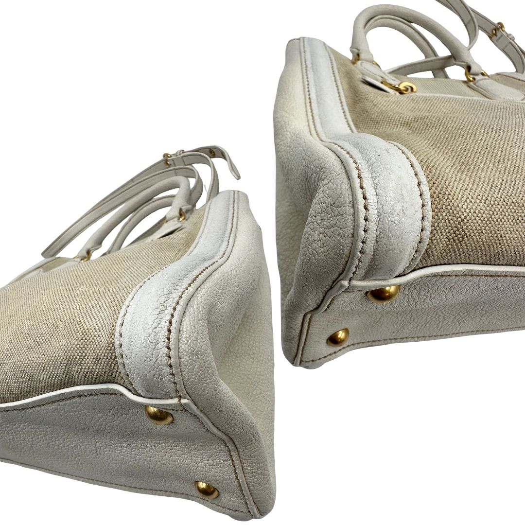 Angoli di una borsa Miu Miu in misto lino avorio con finiture in pelle color bianco latte e parti metalliche dorate; munita di doppi manici stondati ed una tracolla amovibile e regolabile. Completa di card d'autenticità. Indossabile a mano e a tracolla.