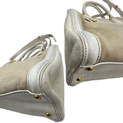 Angoli di una borsa Miu Miu in misto lino avorio con finiture in pelle color bianco latte e parti metalliche dorate; munita di doppi manici stondati ed una tracolla amovibile e regolabile. Completa di card d'autenticità. Indossabile a mano e a tracolla.