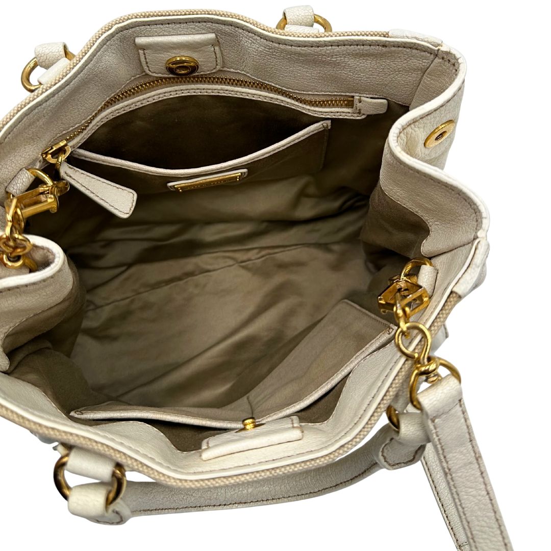 Interno di una borsa Miu Miu in misto lino avorio con finiture in pelle color bianco latte e parti metalliche dorate; munita di doppi manici stondati ed una tracolla amovibile e regolabile. Completa di card d'autenticità. Indossabile a mano e a tracolla.