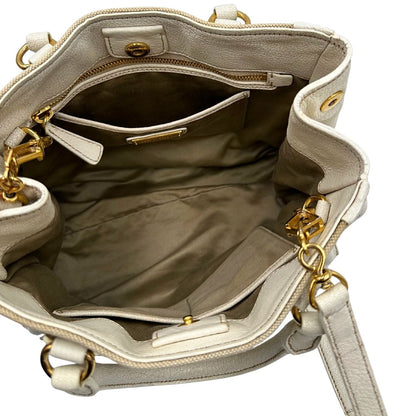 Interno di una borsa Miu Miu in misto lino avorio con finiture in pelle color bianco latte e parti metalliche dorate; munita di doppi manici stondati ed una tracolla amovibile e regolabile. Completa di card d'autenticità. Indossabile a mano e a tracolla.