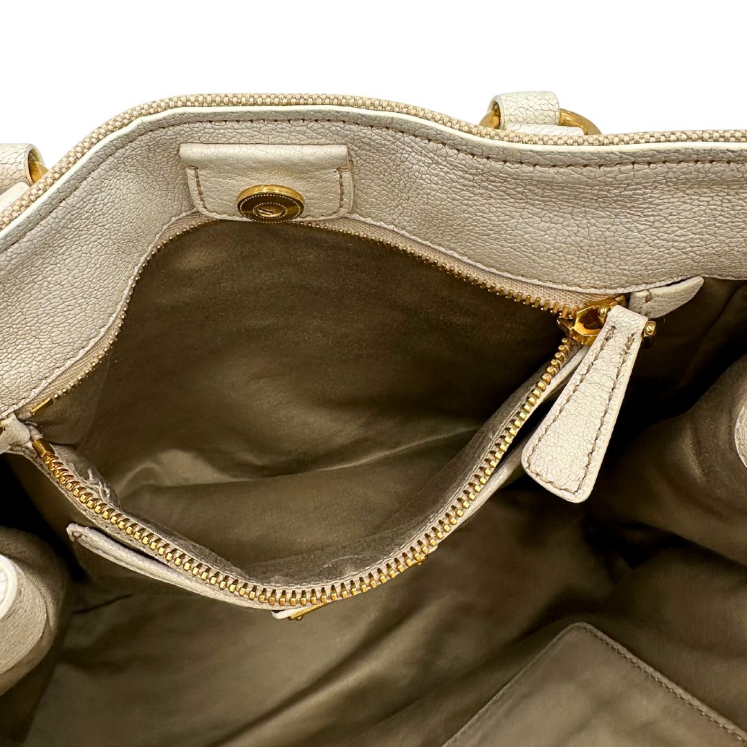 Interno di una borsa Miu Miu in misto lino avorio con finiture in pelle color bianco latte e parti metalliche dorate; munita di doppi manici stondati ed una tracolla amovibile e regolabile. Completa di card d'autenticità. Indossabile a mano e a tracolla.