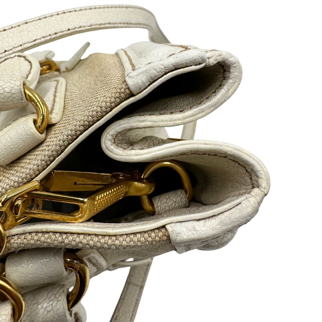 Difetto di una borsa Miu Miu in misto lino avorio con finiture in pelle color bianco latte e parti metalliche dorate; munita di doppi manici stondati ed una tracolla amovibile e regolabile. Completa di card d'autenticità. Indossabile a mano e a tracolla.