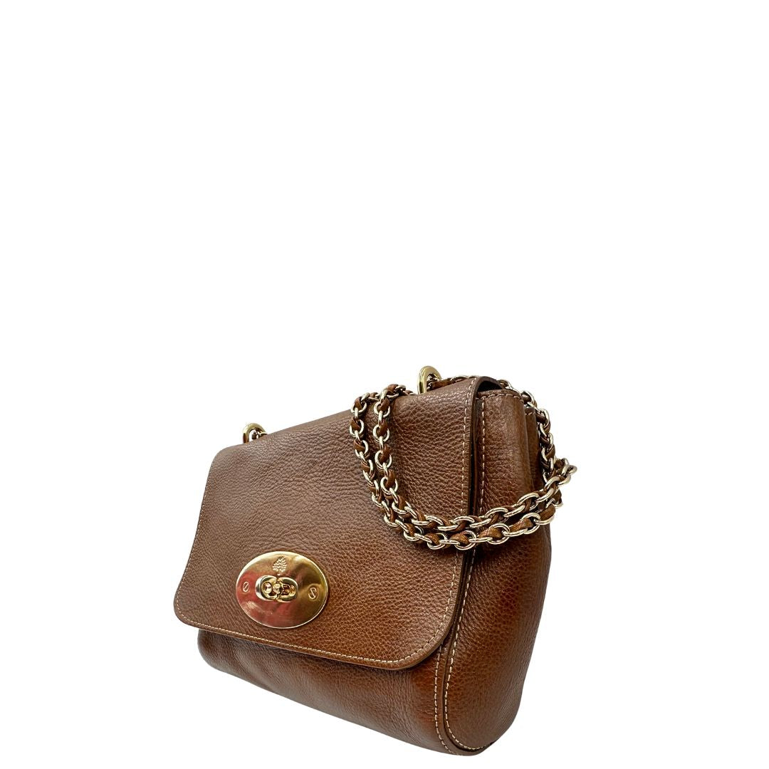 Laterale destro di una borsa Mulberry in pelle martellata nocciola, con parti metalliche dorate, munita di una tracolla in pelle e catena scorrevole. Indossabile a spalla o a tracolla.