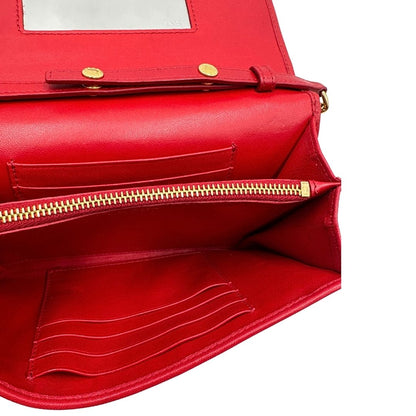 Interno di un wallet Prada in pelle goffrata rossa, impreziosito da logo lettering sul front e specchietto interno; munito di una tracolla in catena amovibile e non regolabile. Completo di scatola.