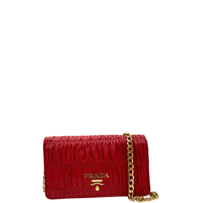 Front di un wallet Prada in pelle goffrata rossa, impreziosito da logo lettering sul front e specchietto interno; munito di una tracolla in catena amovibile e non regolabile. Completo di scatola.