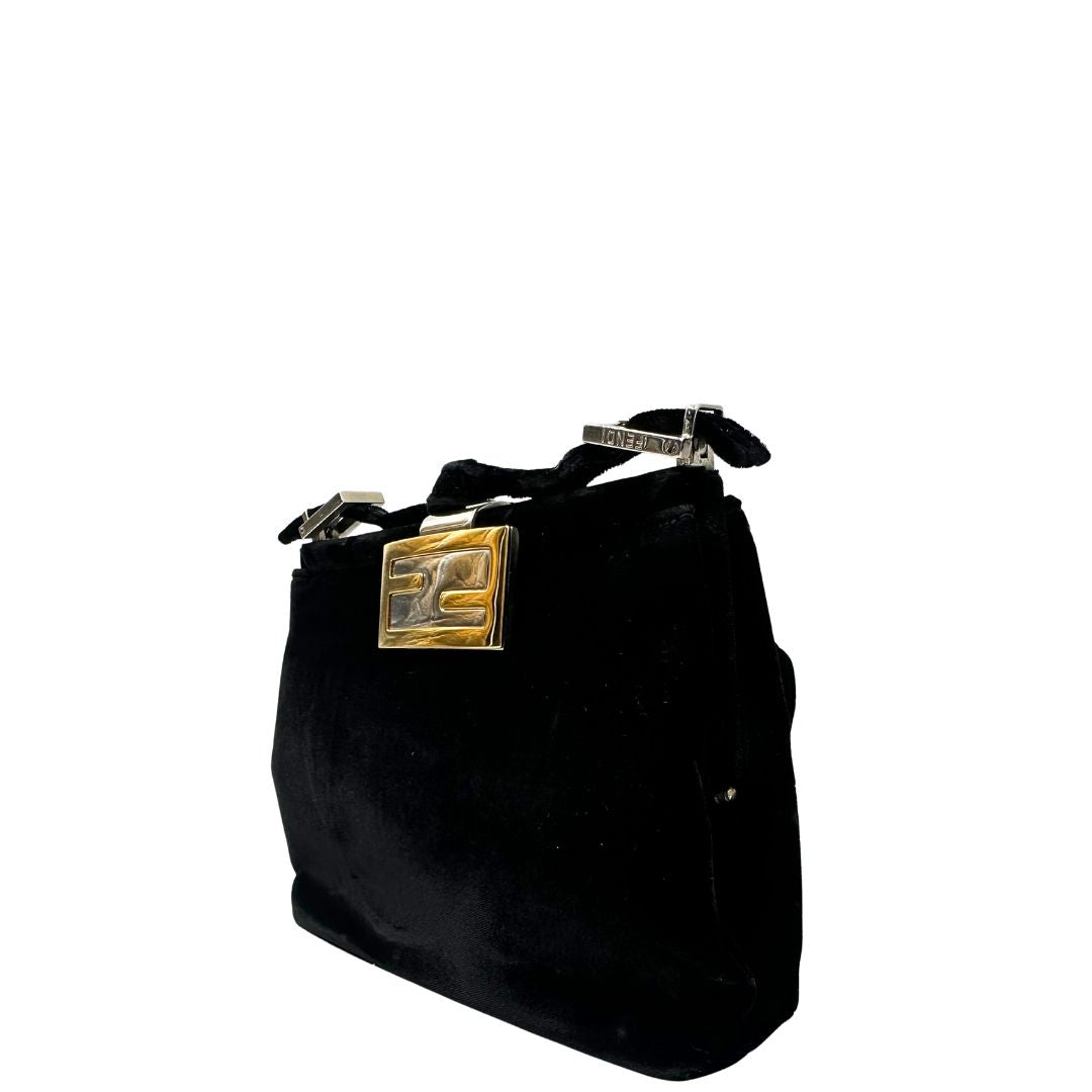 Laterale destro di una borsa Fendi realizzata in velluto nero, con manico leggermente regolabile e con parti metalliche oro e argento. Iconico logo con doppie F come chiusura. Indossabile a spalla. Munita di dustbag.
