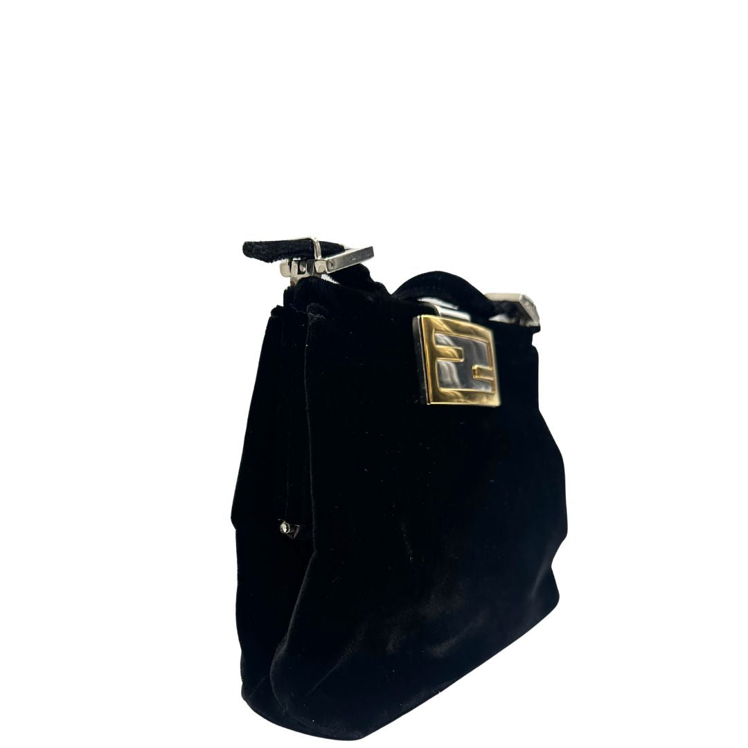 Laterale sinistro di una borsa Fendi realizzata in velluto nero, con manico leggermente regolabile e con parti metalliche oro e argento. Iconico logo con doppie F come chiusura. Indossabile a spalla. Munita di dustbag.