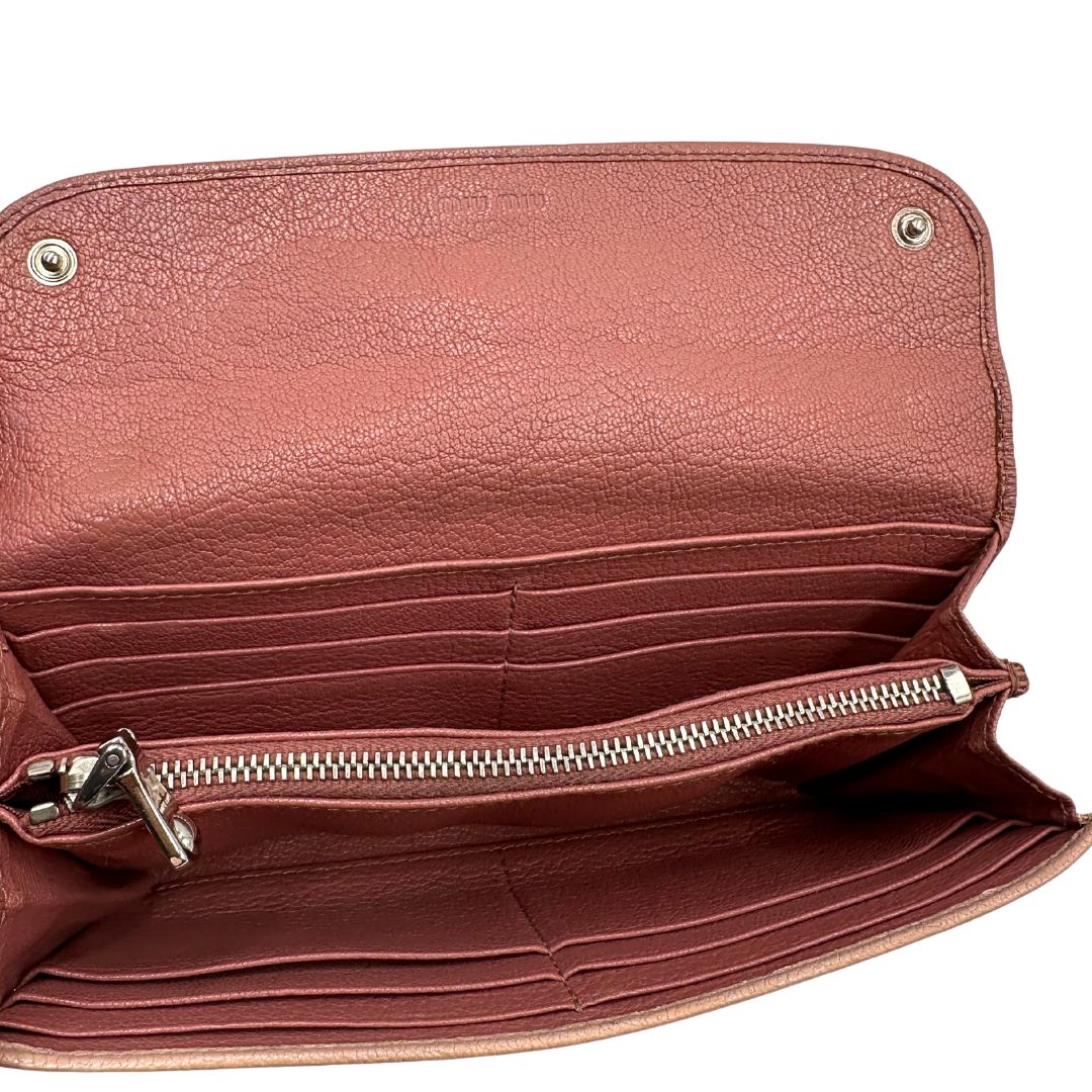 Portafoglio Miu Miu in pelle sulle tonalità del rosa e parti metalliche argentate. Munito di scatola, di lusso, usato, originale, ottime condizioni.