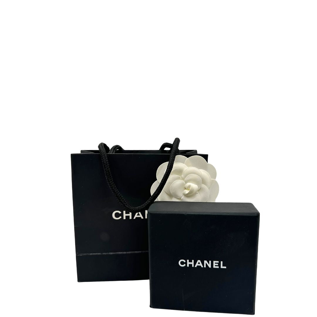 Set di orecchini Chanel dal design rettangolare pendente composto da piccole perle disposte in doppia fila. La parte superiore è decorata da una perla più grande con il logo CC in metallo. 