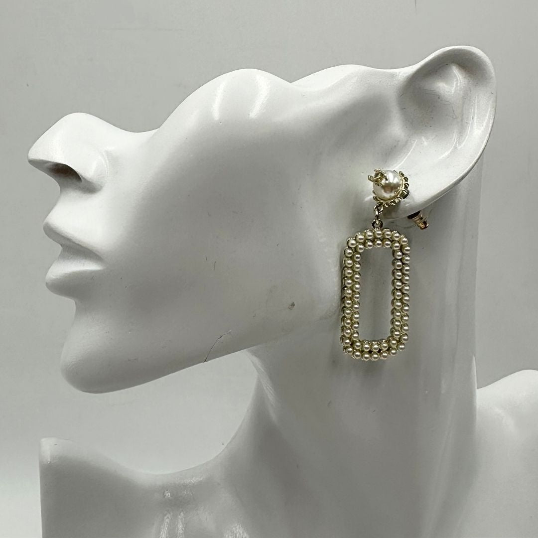 Orecchini Chanel dal design rettangolare pendente composto da piccole perle disposte in doppia fila. La parte superiore è decorata da una perla più grande con il logo CC in metallo. Full set.