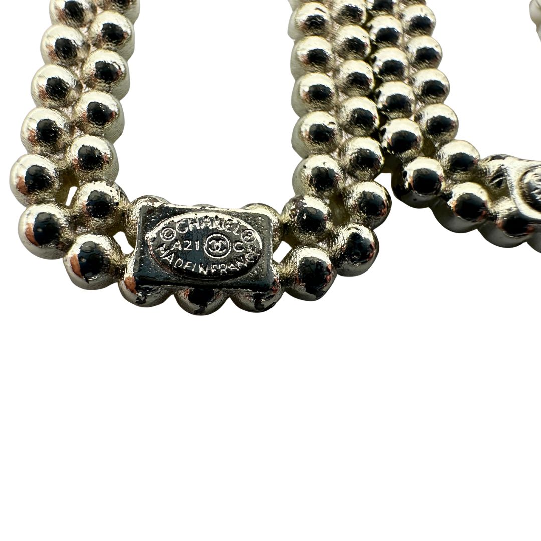 Orecchini Chanel dal design rettangolare pendente composto da piccole perle disposte in doppia fila. La parte superiore è decorata da una perla più grande con il logo CC in metallo. Full set.