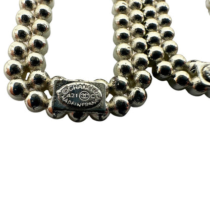 Orecchini Chanel dal design rettangolare pendente composto da piccole perle disposte in doppia fila. La parte superiore è decorata da una perla più grande con il logo CC in metallo. Full set.