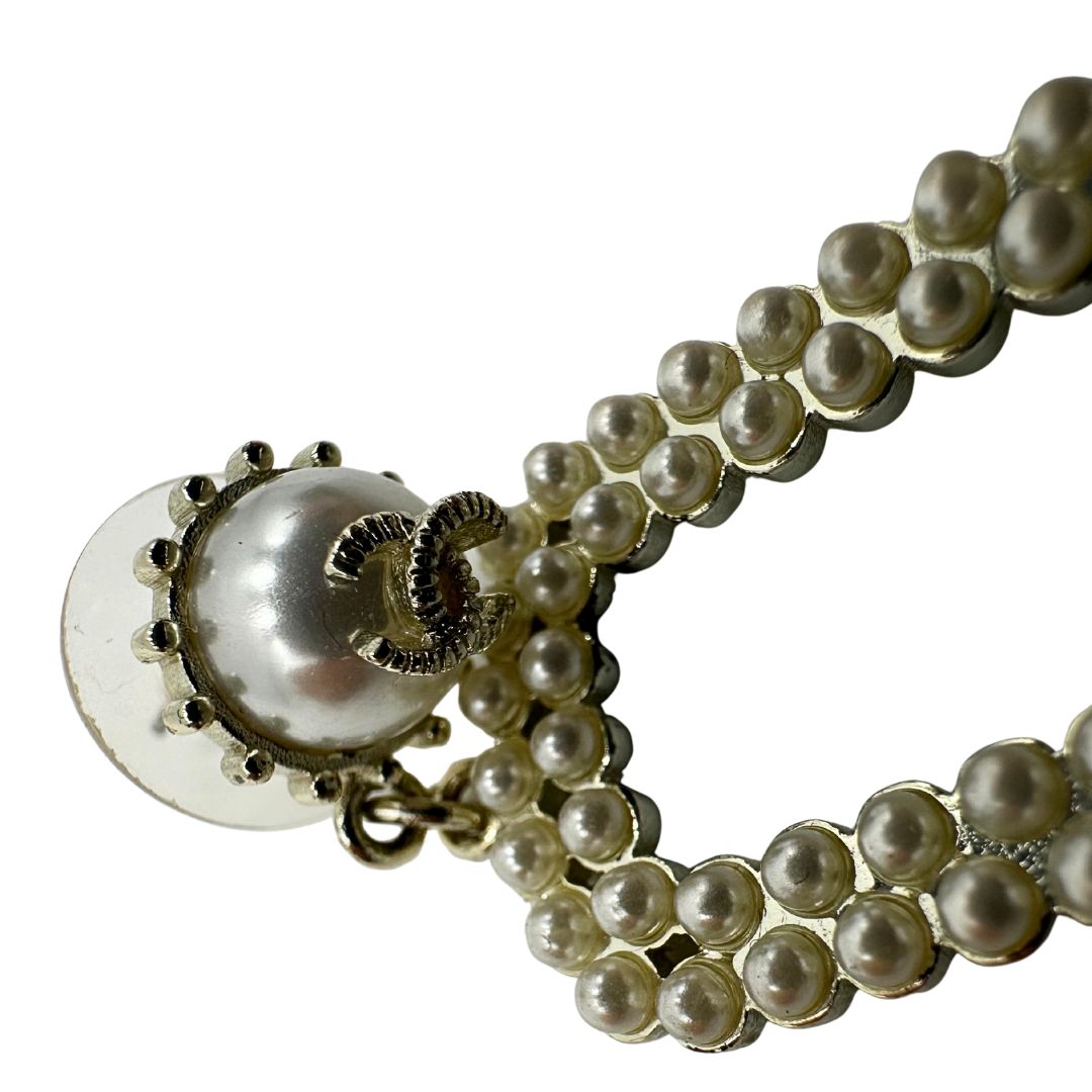 Orecchini Chanel dal design rettangolare pendente composto da piccole perle disposte in doppia fila. La parte superiore è decorata da una perla più grande con il logo CC in metallo. Full set.