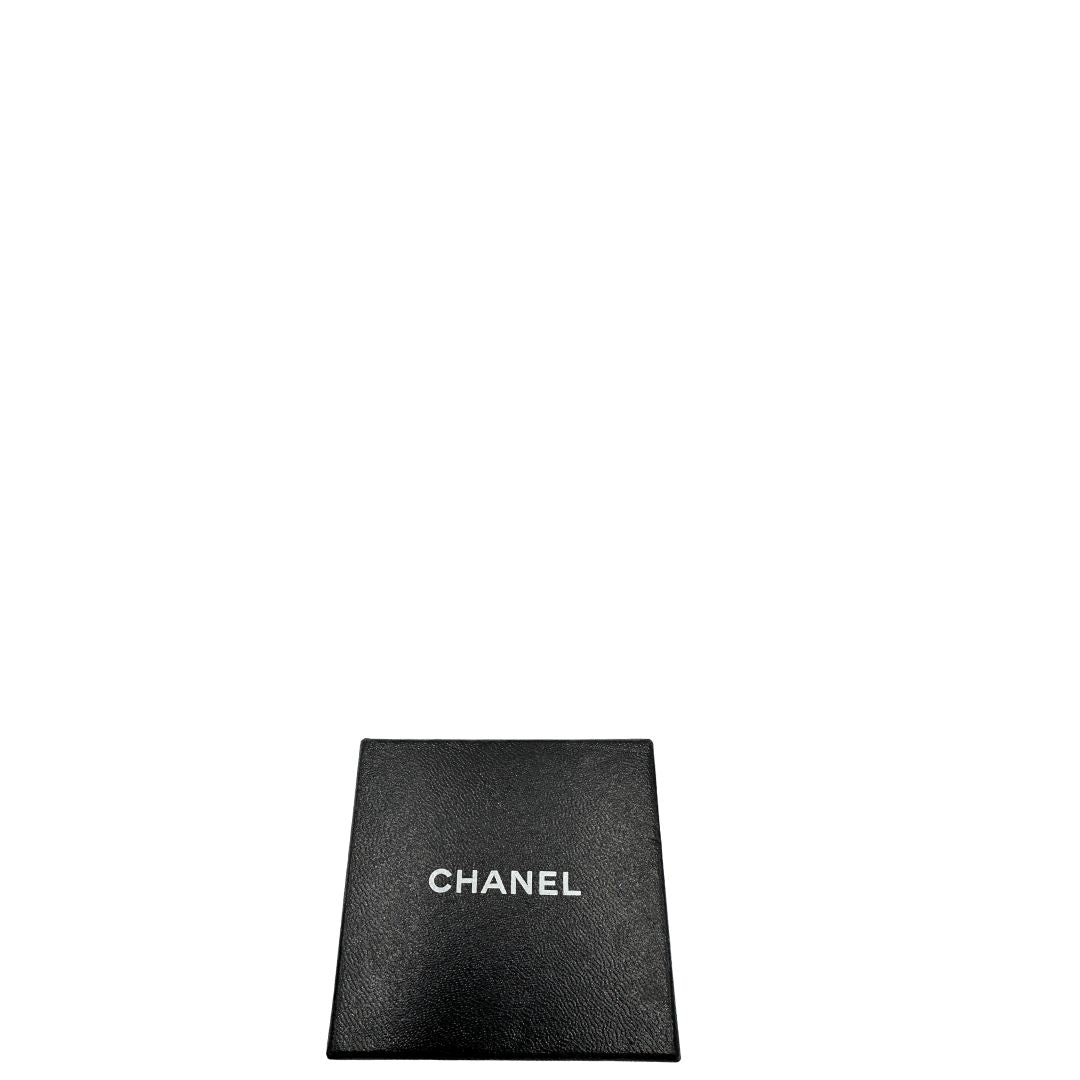 Scatola di orecchini Chanel vintage a clip, caratterizzati da una montatura in metallo dorato martellata che incornicia una grande perla artificiale centrale dal finish iridescente. 