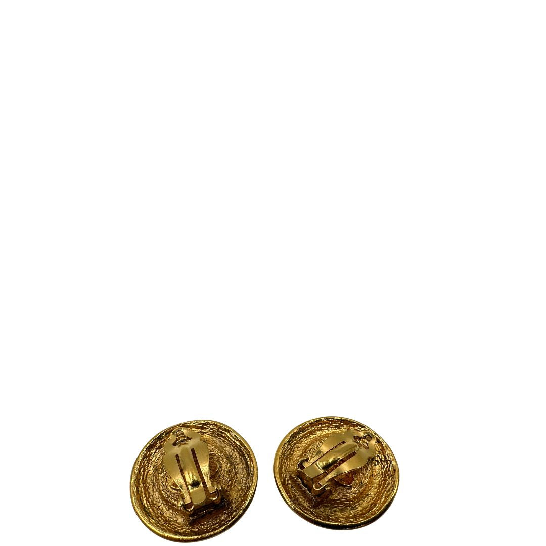 Orecchini Chanel vintage a clip, caratterizzati da una montatura in metallo dorato martellata che incornicia una grande perla artificiale centrale dal finish iridescente. Completi di scatola.