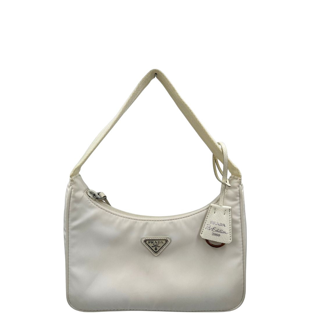 Front di una borsa Prada Re-Edition 2000 in econylon color bianco gesso con dettagli in pelle Saffiano tono su tono e parti metalliche argentate. Completa di corredo.