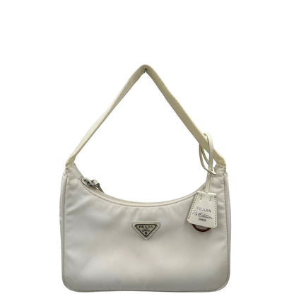 Front di una borsa Prada Re-Edition 2000 in econylon color bianco gesso con dettagli in pelle Saffiano tono su tono e parti metalliche argentate. Completa di corredo.