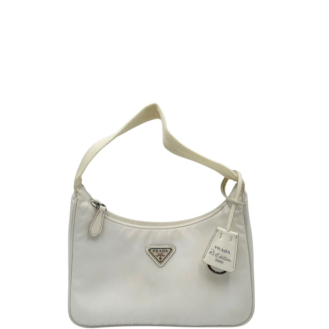Front di una borsa Prada Re-Edition 2000 in econylon color bianco gesso con dettagli in pelle Saffiano tono su tono e parti metalliche argentate. Completa di corredo.