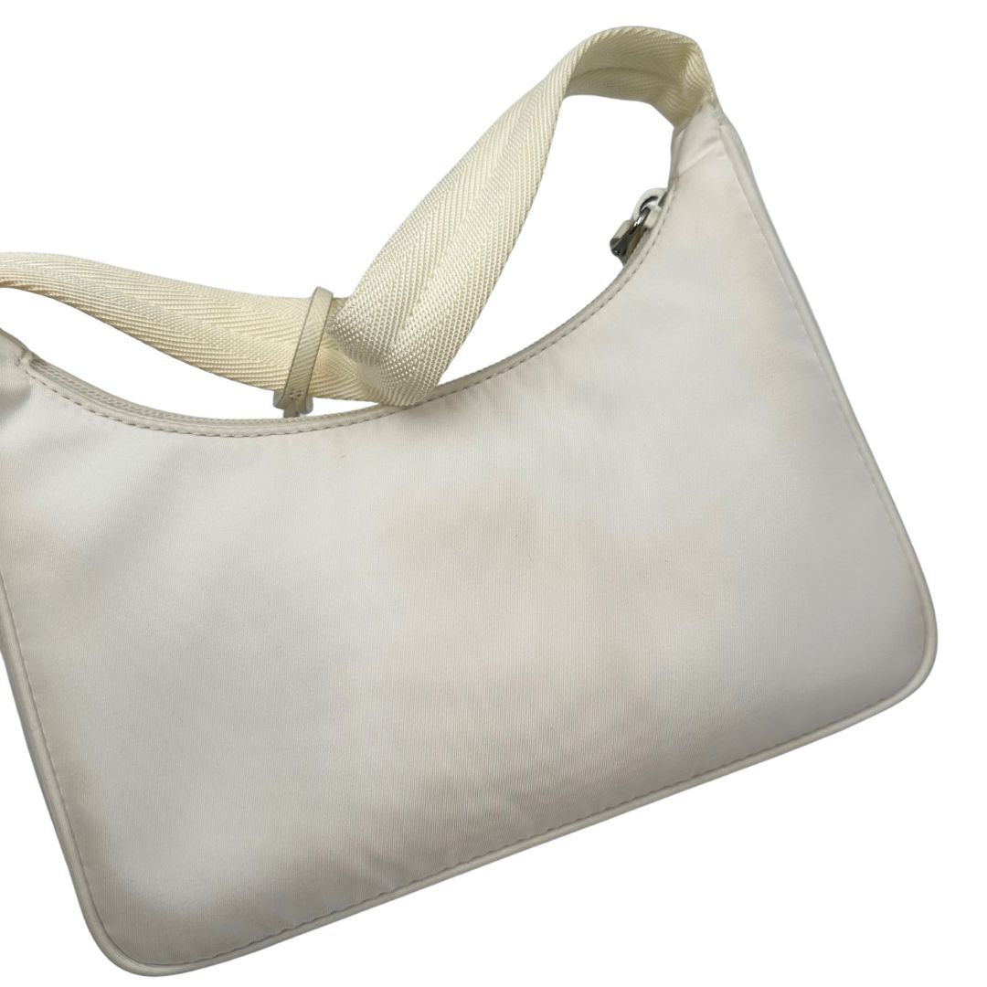 Retro di una borsa Prada Re-Edition 2000 in econylon color bianco gesso con dettagli in pelle Saffiano tono su tono e parti metalliche argentate. Completa di corredo.