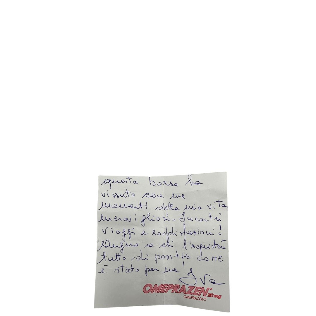 Biglietto della precedente cliente di un Keepall Bandoulière in canvas monogram con finiture in vacchetta naturale e parti metalliche dorate; munito di doppi manici stondati e una tracolla amovibile e regolabile on spallaccio. Completo di lucchetto con chiave, tag porta address e ferma manici.