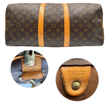 Base e codice di un Keepall Bandoulière in canvas monogram con finiture in vacchetta naturale e parti metalliche dorate; munito di doppi manici stondati e una tracolla amovibile e regolabile on spallaccio. Completo di lucchetto con chiave, tag porta address e ferma manici.