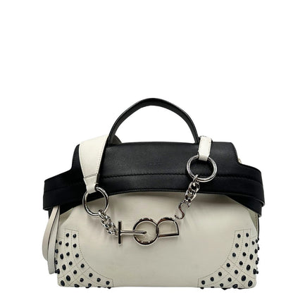Front di una borsa Wave Tod's in pelle bianca e nera impreziosita da iconici gommini Tod's sugli angoli della base. Munita di un manico singolo stondato, una tracolla con lettere in catena e pelle, regolabile ed amovibile. Parti metalliche argentate. Dotata di dustbag.