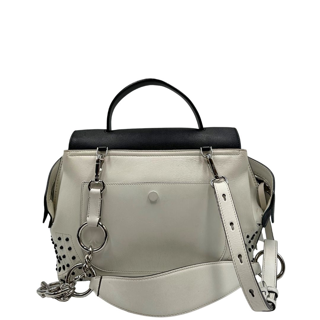 Retro di una borsa Wave Tod's in pelle bianca e nera impreziosita da iconici gommini Tod's sugli angoli della base. Munita di un manico singolo stondato, una tracolla con lettere in catena e pelle, regolabile ed amovibile. Parti metalliche argentate. Dotata di dustbag.