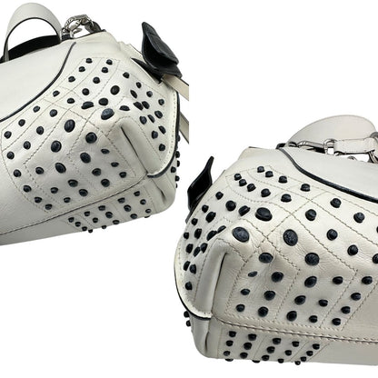 Angoli di una borsa Wave Tod's in pelle bianca e nera impreziosita da iconici gommini Tod's sugli angoli della base. Munita di un manico singolo stondato, una tracolla con lettere in catena e pelle, regolabile ed amovibile. Parti metalliche argentate. Dotata di dustbag.