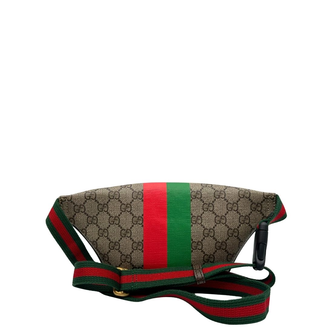 Retro di un marsupio Gucci in canvas beige GG con metalleria dorata e finiture in pelle marroni. Stampa Gucci Tiger e fascia Web su front e retro. Tracolla in tessuto Web verde/rosso, regolabile. Completo di dustbag. Indossabile a marsupio o crossbody.