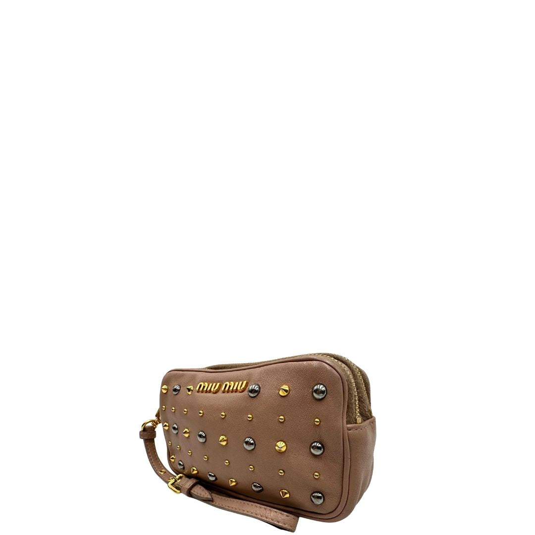 lato Pochette Miu Miu in pelle color taupe con doppia zip, borchie metalliche frontali oro e argento con dettagli hardware dorati. Dotata di polsino regolabile e due scomparti interni foderati in pelle. Completa di scatola. 