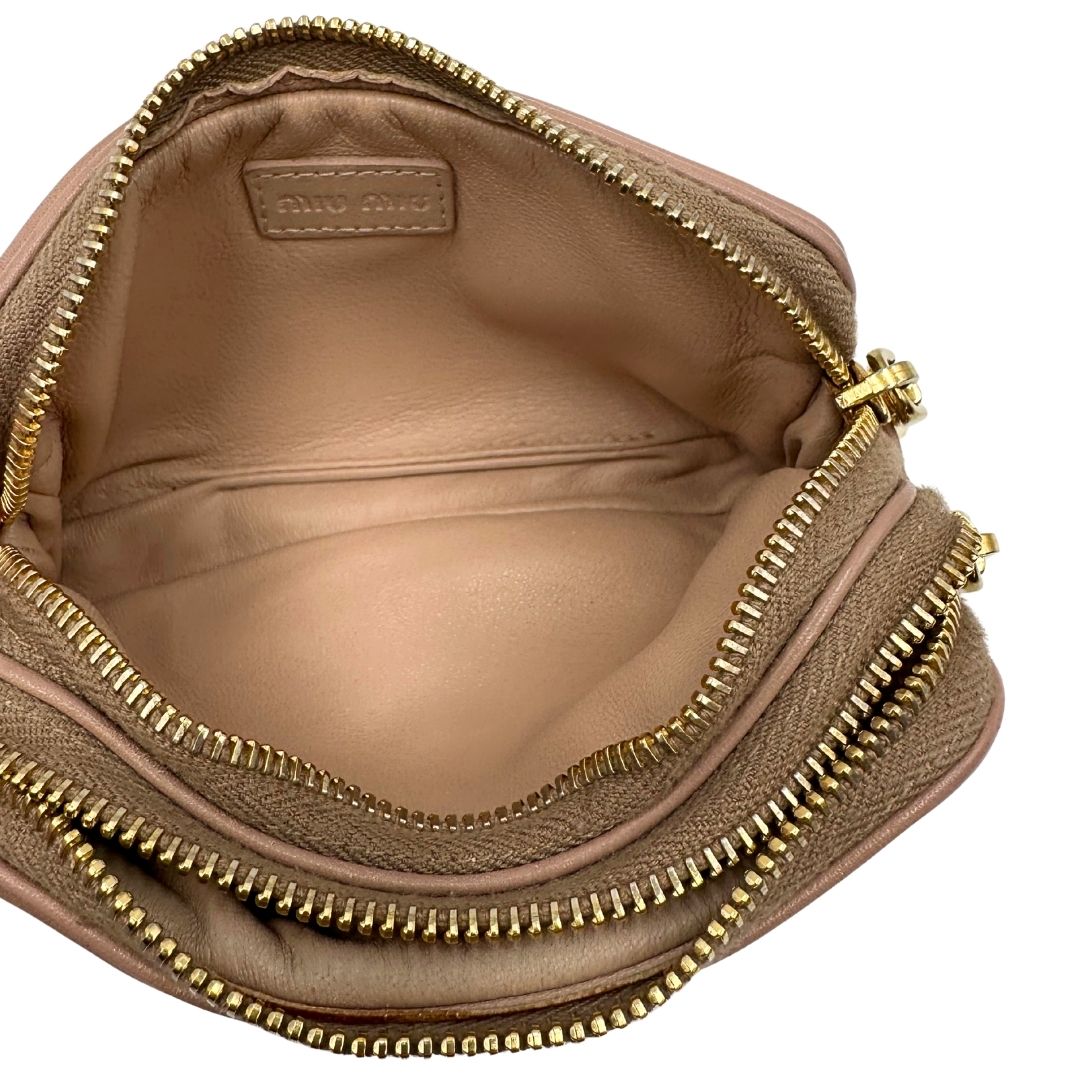 interno Pochette Miu Miu in pelle color taupe con doppia zip, borchie metalliche frontali oro e argento con dettagli hardware dorati. Dotata di polsino regolabile e due scomparti interni foderati in pelle. Completa di scatola. 