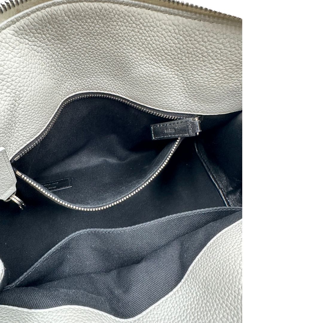 Interno di una Sac De Jour small Saint Laurent in pelle martellata bianco gesso con doppi manici stondati e tracolla in catena e pelle, regolabile ed amovibile. Parti metalliche argentate. Munita di clochette con lucchetto e chiavi.