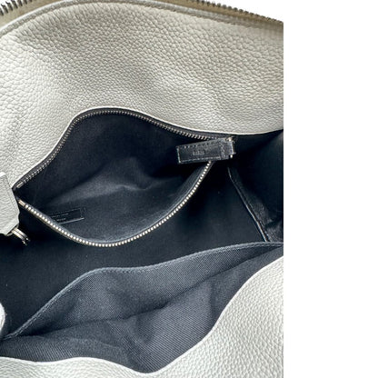 Interno di una Sac De Jour small Saint Laurent in pelle martellata bianco gesso con doppi manici stondati e tracolla in catena e pelle, regolabile ed amovibile. Parti metalliche argentate. Munita di clochette con lucchetto e chiavi.