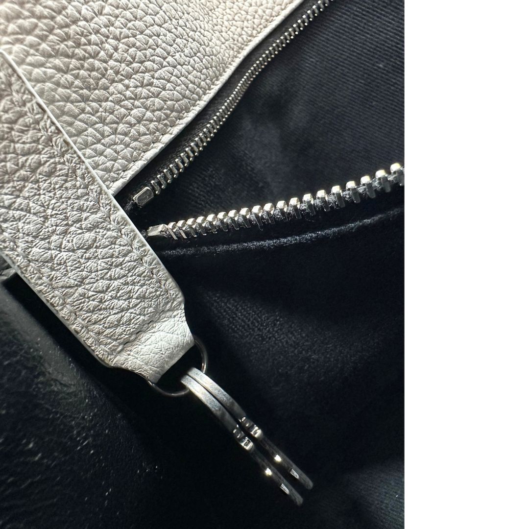 Chiavi di una Sac De Jour small Saint Laurent in pelle martellata bianco gesso con doppi manici stondati e tracolla in catena e pelle, regolabile ed amovibile. Parti metalliche argentate. Munita di clochette con lucchetto.