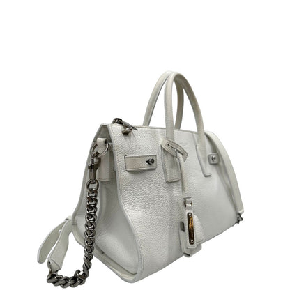 Laterale sinistro di una Sac De Jour small Saint Laurent in pelle martellata bianco gesso con doppi manici stondati e tracolla in catena e pelle, regolabile ed amovibile. Parti metalliche argentate. Munita di clochette con lucchetto e chiavi.