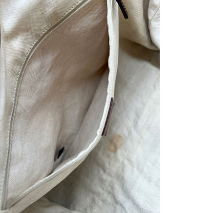 Interno di una borsa Gucci Sukey in tessuto beige GG con finiture in pelle marrone mogano, doppi manici stondati e ciondolo con doppie G incrociate. Rifinita con parti metalliche dorate. Indossabile a spalla.