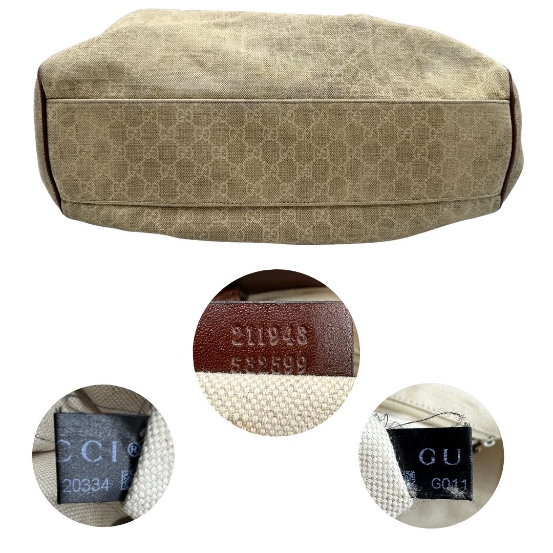 Base e codici di una borsa Gucci Sukey in tessuto beige GG con finiture in pelle marrone mogano, doppi manici stondati e ciondolo con doppie G incrociate. Rifinita con parti metalliche dorate. Indossabile a spalla.