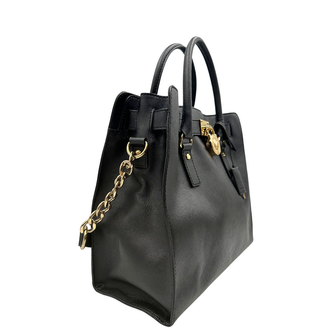 lato  Borsa Michael Kors in pelle saffiano nera con parti metalliche dorate; munita di doppi manici e una tracolla amovibile in catena e pelle, di lusso, originale, ottime condizioni. 