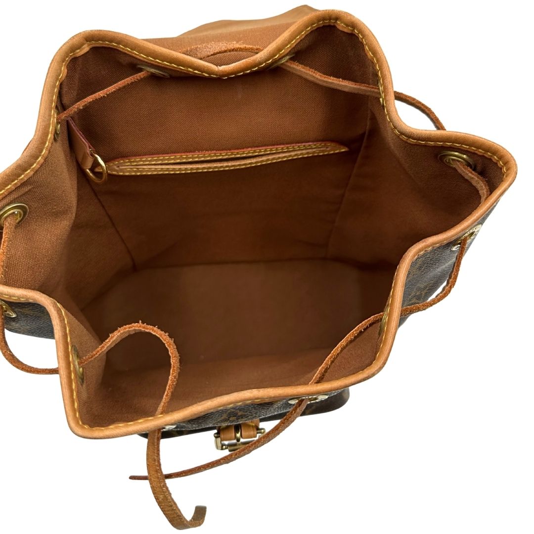 interno Zaino Montsouris mini in canvas marrone monogram con finiture in vacchetta naturale e parti metalliche dorate, munito di un anello sulla parte superiore e due bretelle in vacchetta regolabili con fibbie. Completo di dustbag, di lusso, originale, ottime condizioni.