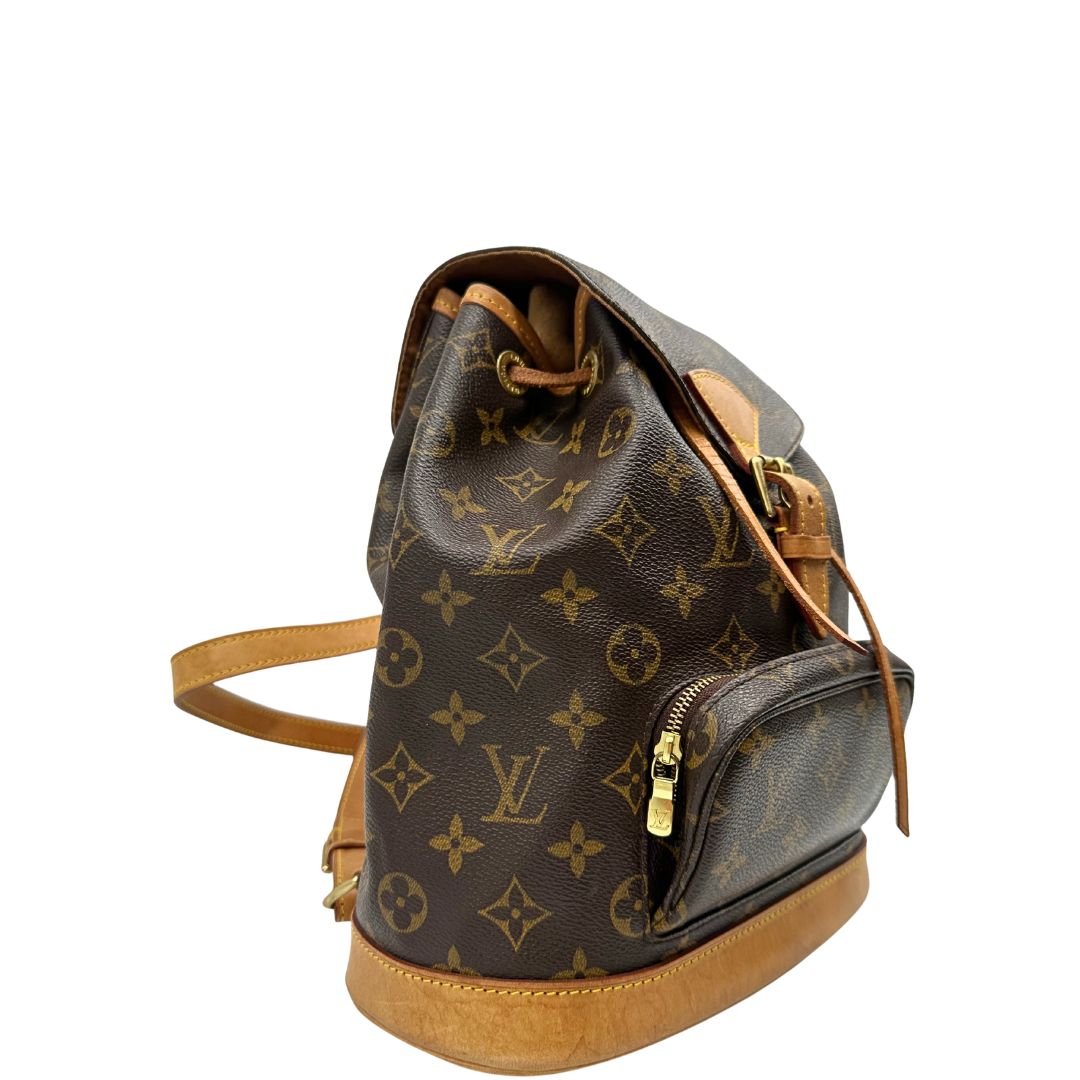 lato Zaino Montsouris mini in canvas marrone monogram con finiture in vacchetta naturale e parti metalliche dorate, munito di un anello sulla parte superiore e due bretelle in vacchetta regolabili con fibbie. Completo di dustbag, di lusso, originale, ottime condizioni. 