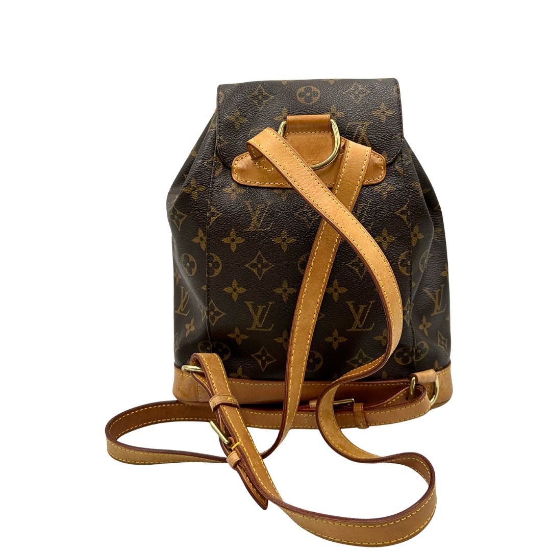 retro Zaino Montsouris mini in canvas marrone monogram con finiture in vacchetta naturale e parti metalliche dorate, munito di un anello sulla parte superiore e due bretelle in vacchetta regolabili con fibbie. Completo di dustbag, di lusso, originale, ottime condizioni. 