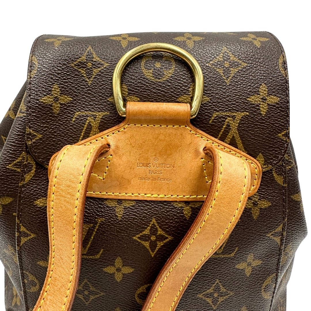manico Zaino Montsouris mini in canvas marrone monogram con finiture in vacchetta naturale e parti metalliche dorate, munito di un anello sulla parte superiore e due bretelle in vacchetta regolabili con fibbie. Completo di dustbag, di lusso, originale, ottime condizioni. 