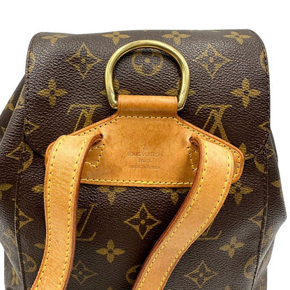 manico Zaino Montsouris mini in canvas marrone monogram con finiture in vacchetta naturale e parti metalliche dorate, munito di un anello sulla parte superiore e due bretelle in vacchetta regolabili con fibbie. Completo di dustbag, di lusso, originale, ottime condizioni. 