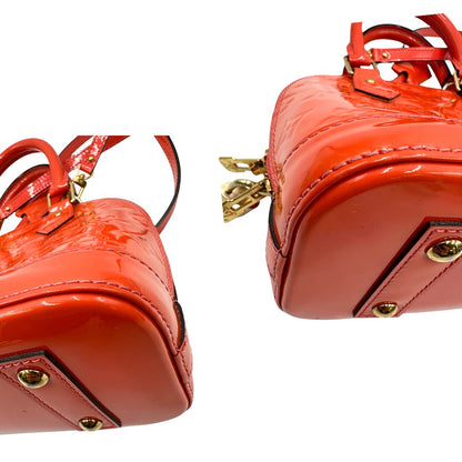 angoli Borsa Louis Vuitton Alma BB in pelle Vernis arancione corallo monogram e parti metalliche dorate. Munita di doppi manici stondati e una tracolla amovibile, dotata di clochette porta chiavi. Completa di dustbag, lucchetto e chiavi, di lusso, originale, ottime condizioni, usata. 