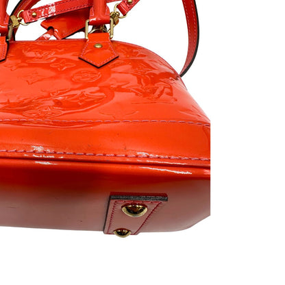 base Borsa Louis Vuitton Alma BB in pelle Vernis arancione corallo monogram e parti metalliche dorate. Munita di doppi manici stondati e una tracolla amovibile, dotata di clochette porta chiavi. Completa di dustbag, lucchetto e chiavi, di lusso, originale, ottime condizioni, usata. 